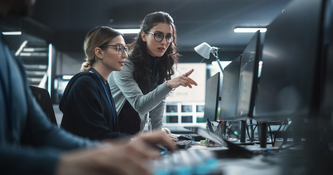 Two Cybersecurity Professionals Working on Monitors.