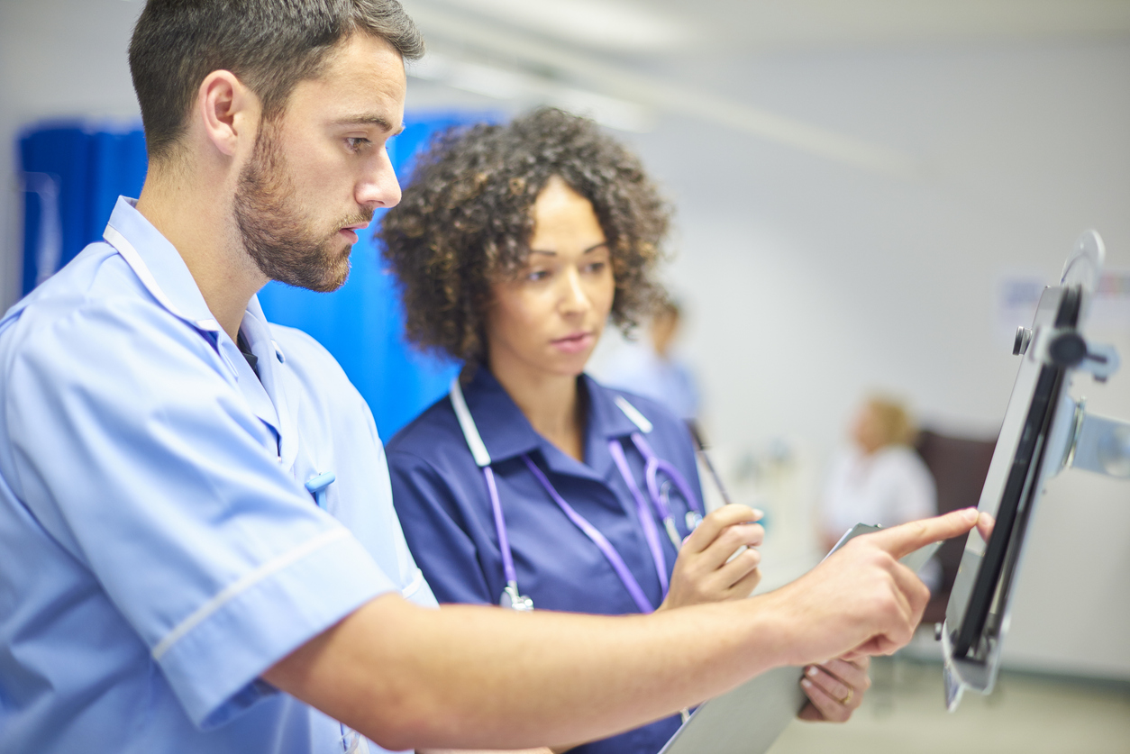 Nursing Informatics Professionals Looking at Data on a Tablet.