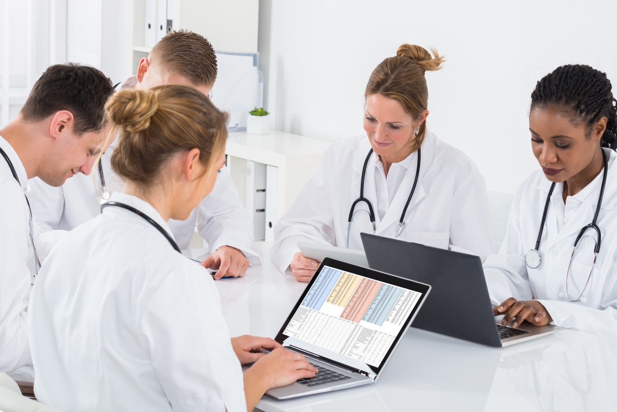 Medical Professionals Sitting Together on Laptops in a Medical Facility.