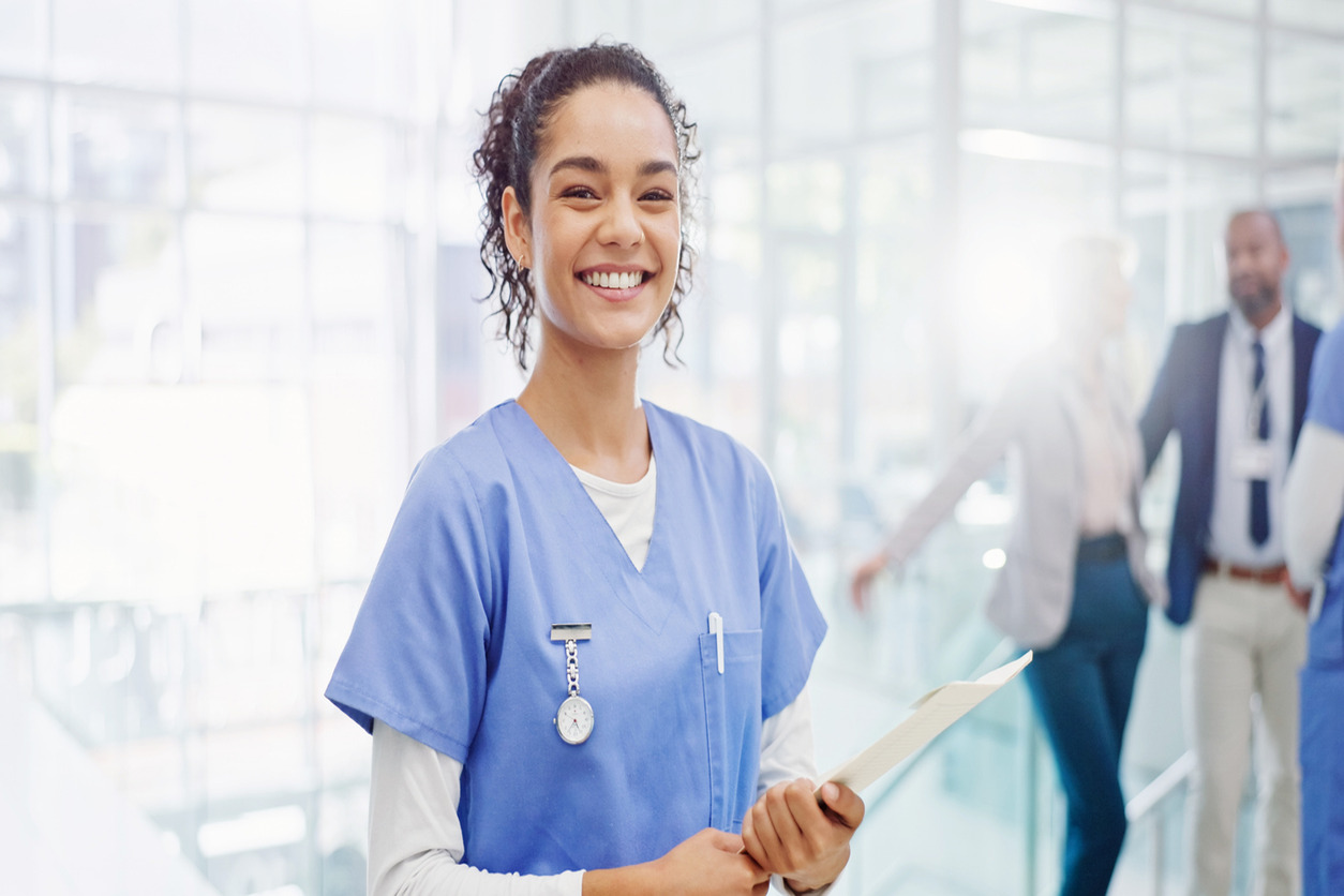 A Nurse Smiling and Holding a Clipboard