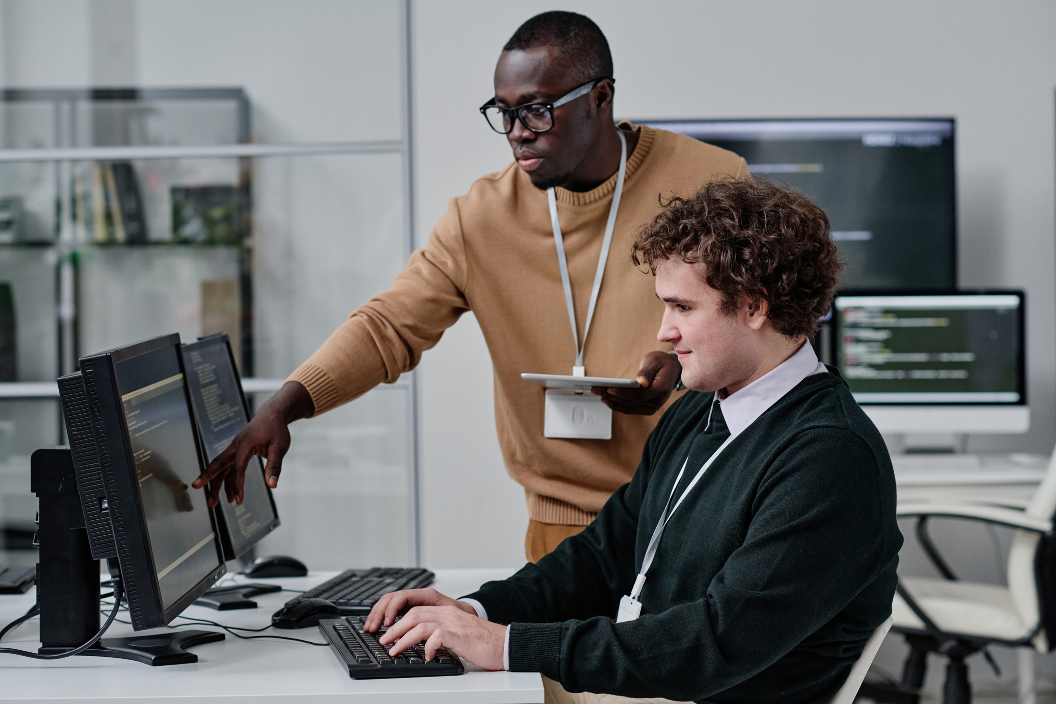 Cybersecurity professionals review code on a monitor.