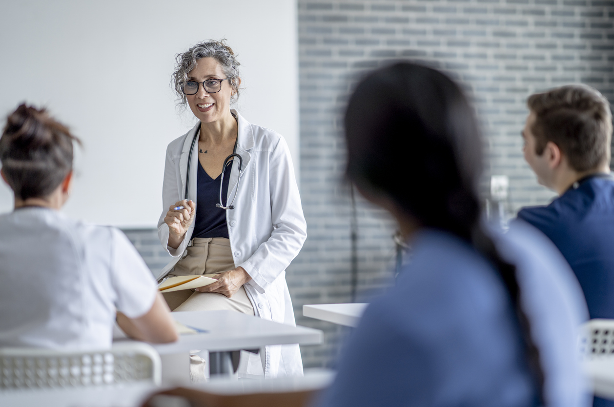A nurse educator teaches students in a classroom.