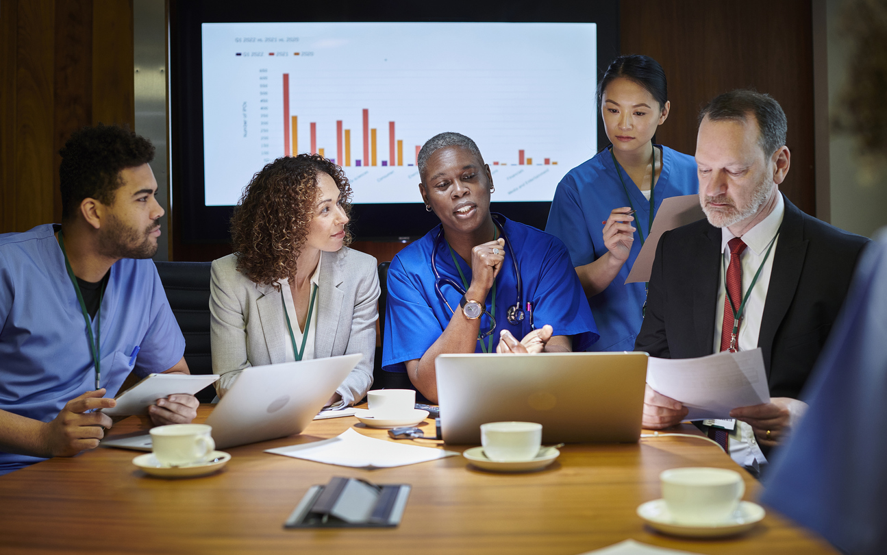 Nurses meet with public health officials around a conference table.