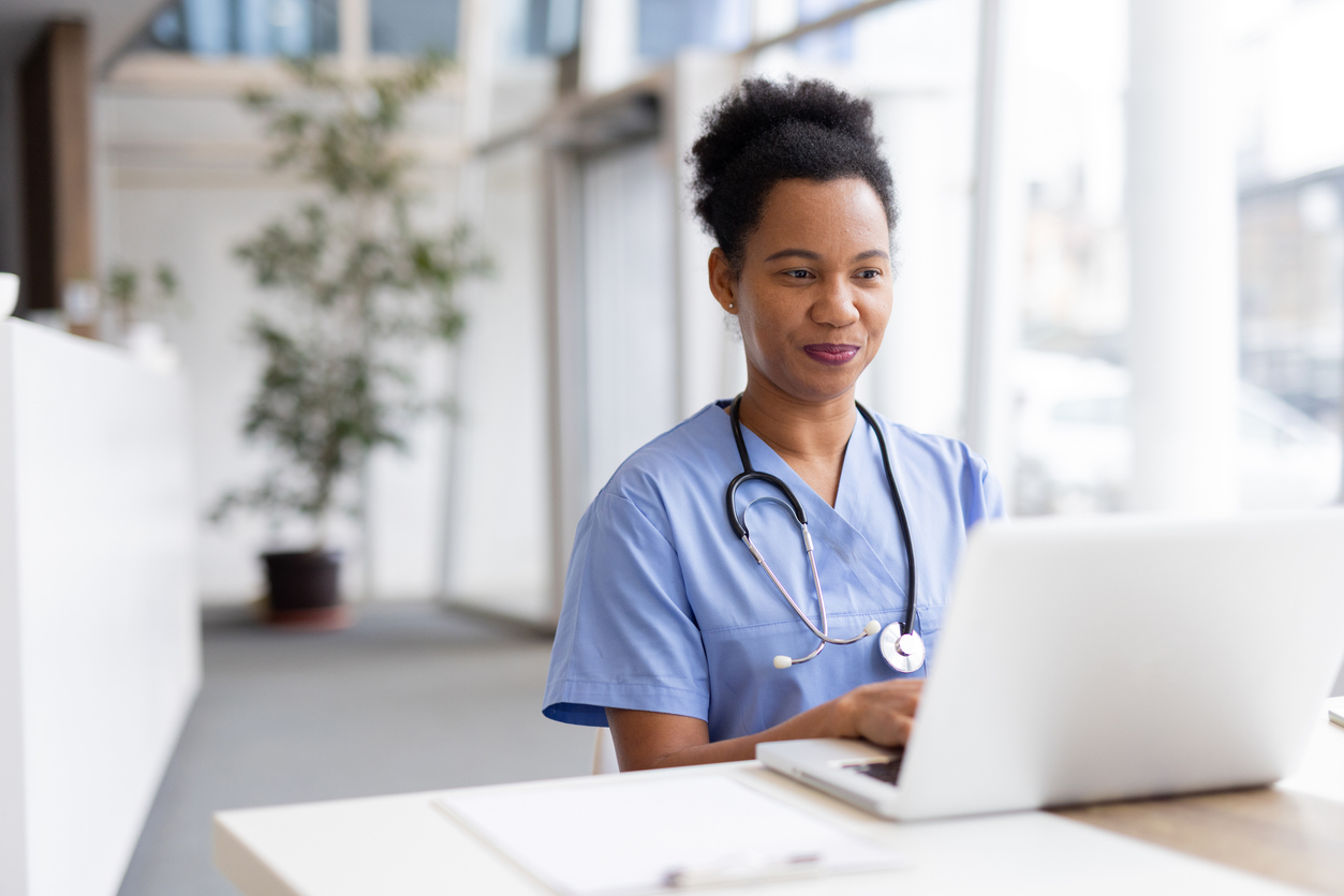 A Nurse Sitting at a Desk Working on a Laptop..jpg