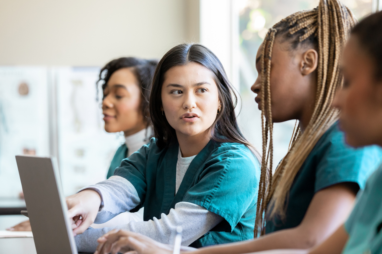 A group of nursing students study using a laptop computer.