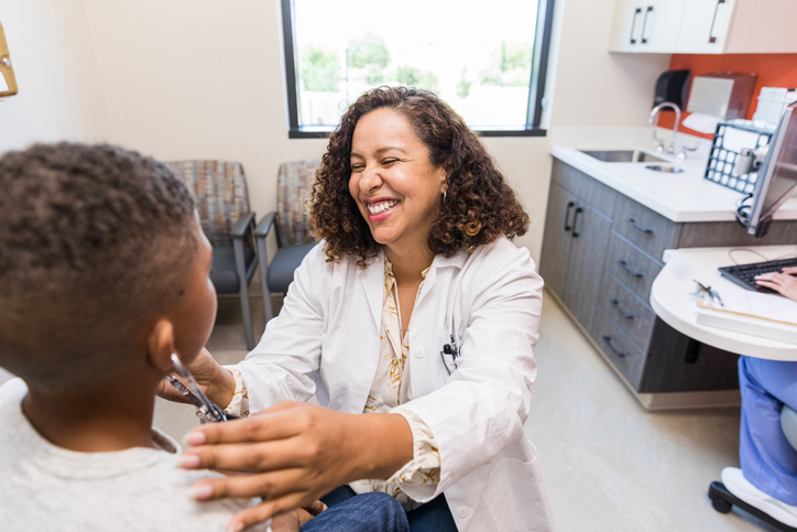 A rural nurse engages with a young patient in an examination room.