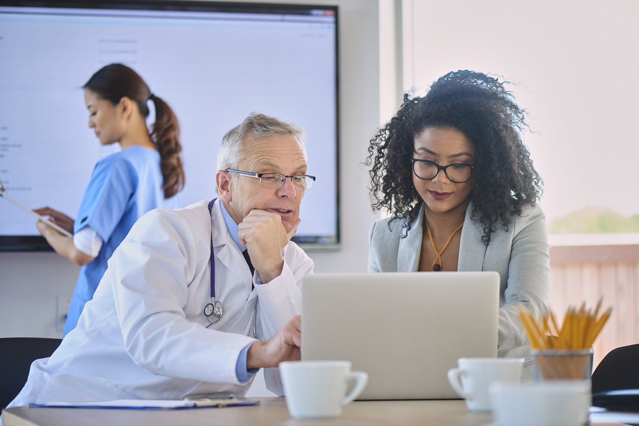 A Cybersecurity Professional Shows a Physician How to Access a Secure Laptop.