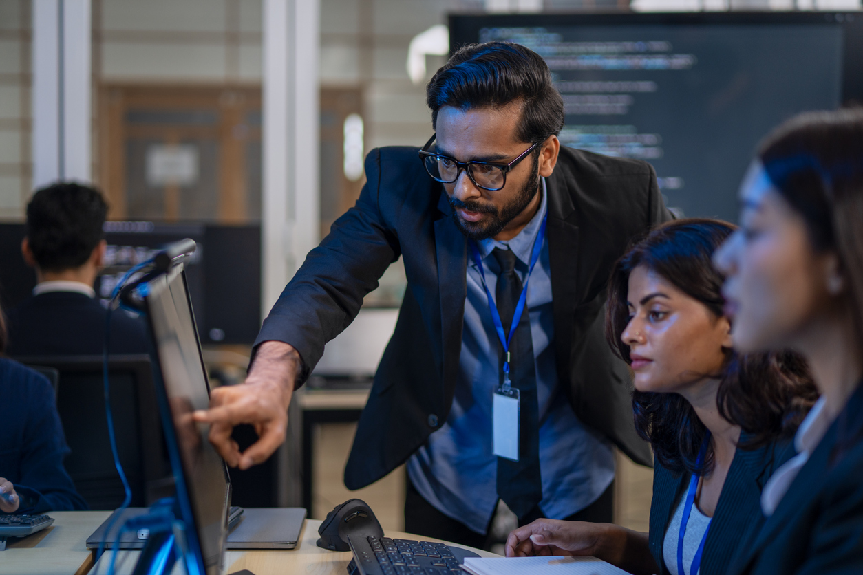 Cybersecurity professionals working together at computer monitors.